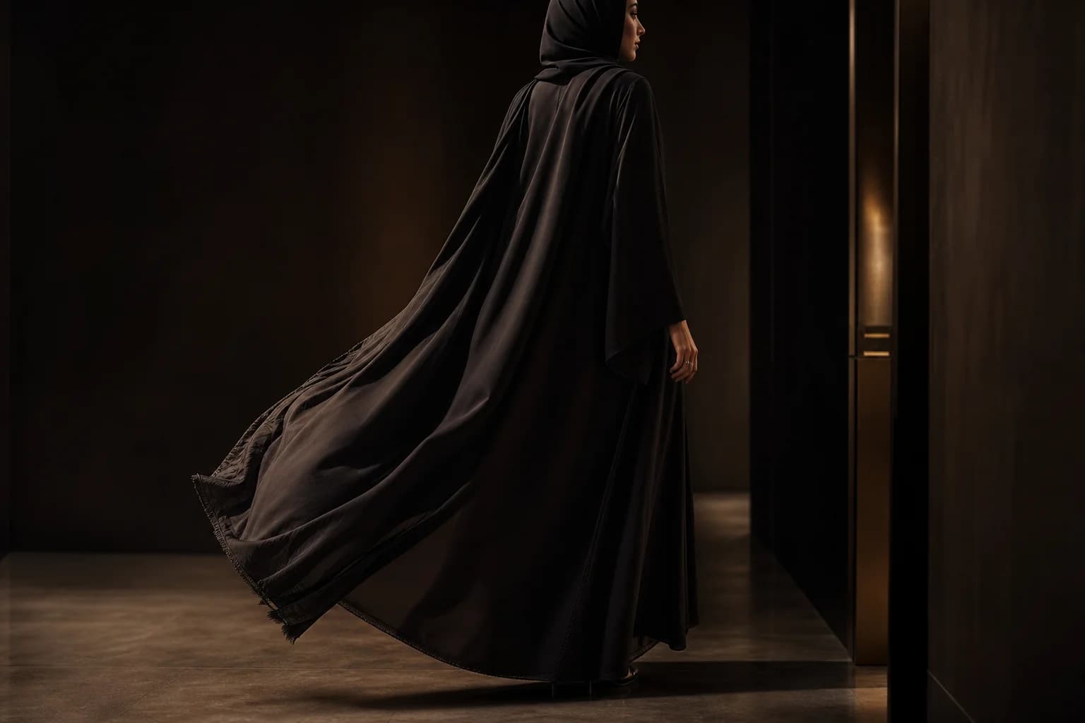 Black abaya fabric moving through light
